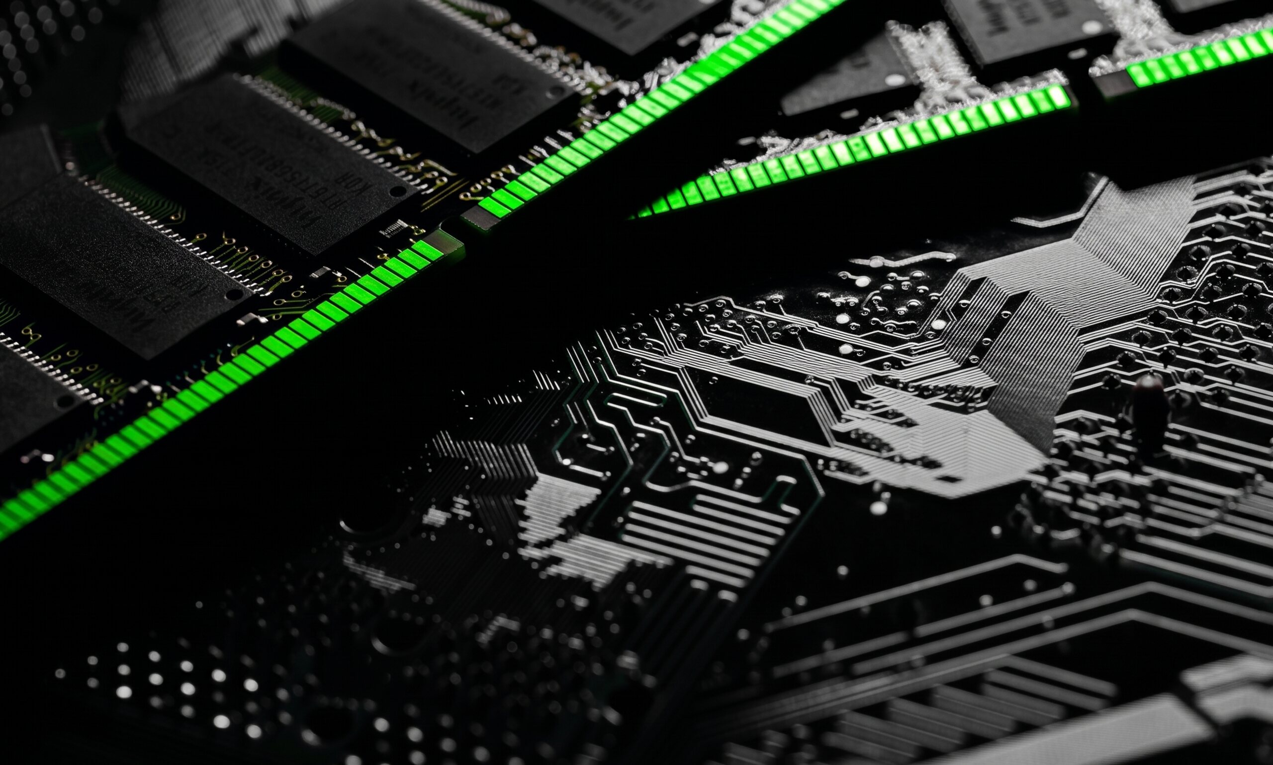 Close-up of a circuit board with green illuminated memory modules